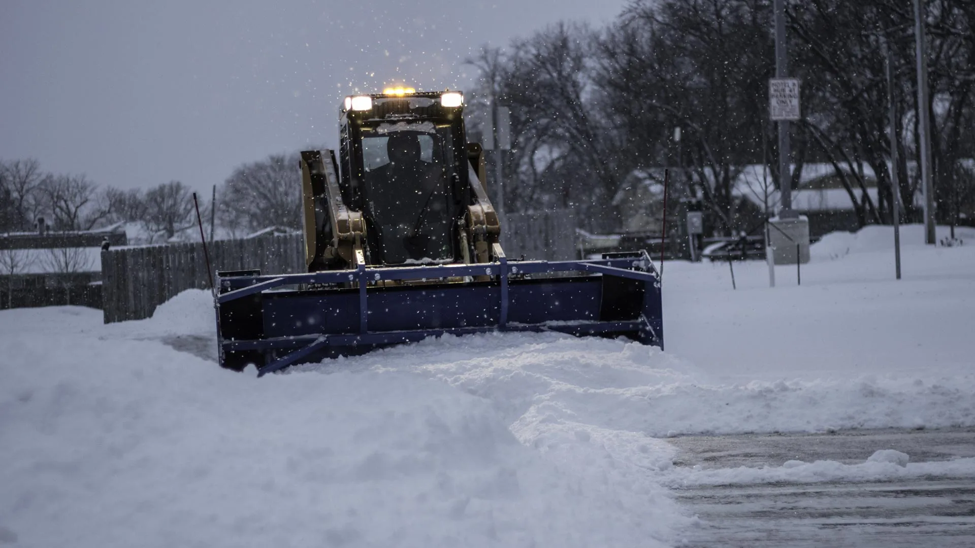Snow plowing a commercial parking lot and treating with deicer in Detroit Lakes, MN